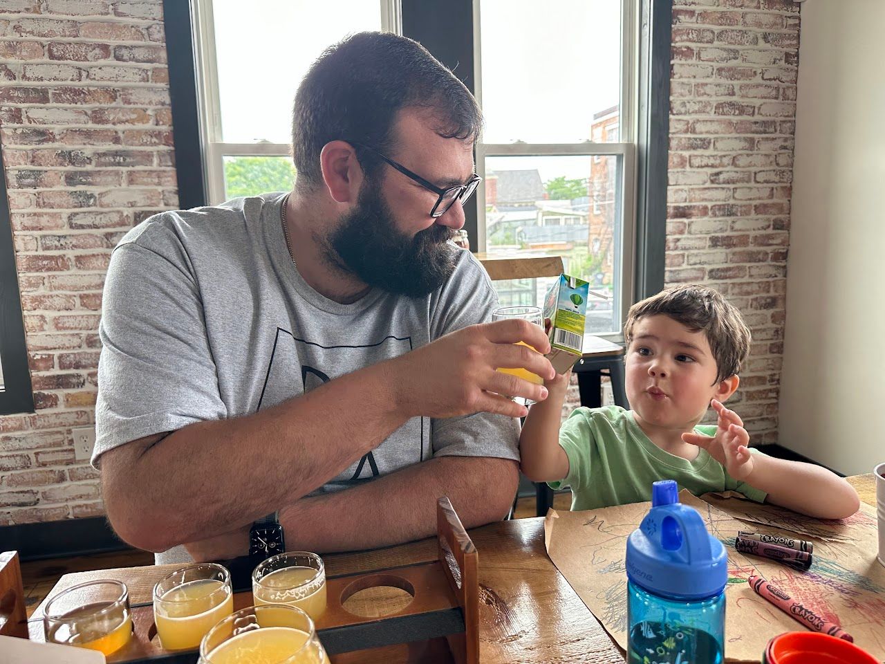 My son and I clinking our drinks at a local pizza brewery